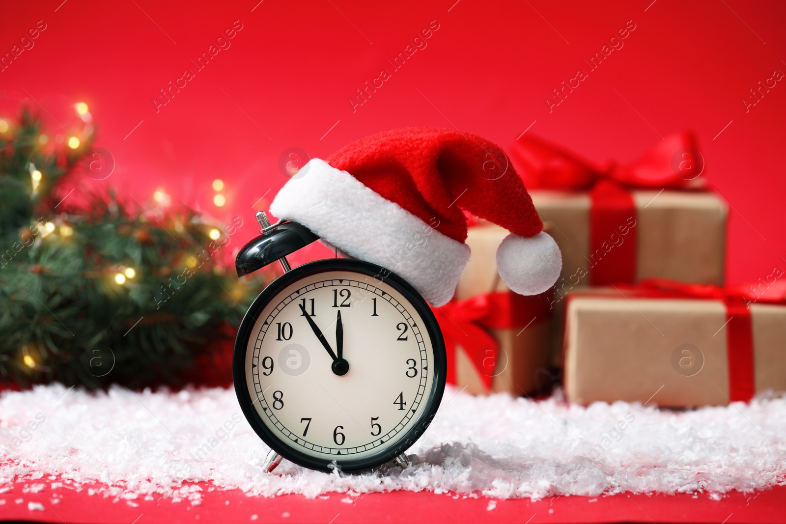 Photo of Alarm clock on snow against blurred background. New Year countdown