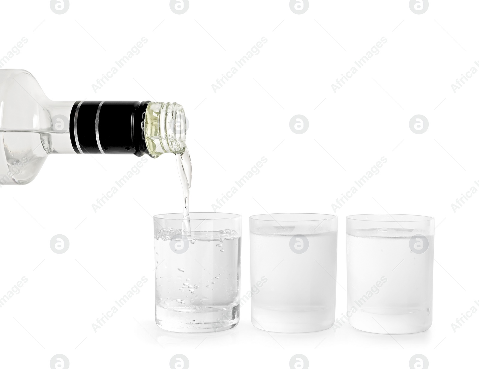 Photo of Pouring vodka from bottle in glass on white background