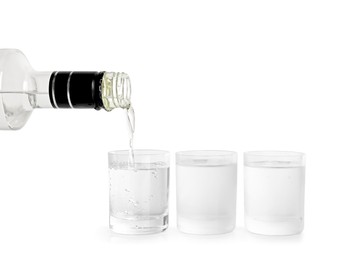 Photo of Pouring vodka from bottle in glass on white background