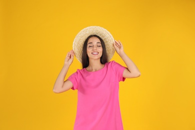 Photo of Young woman wearing stylish pink dress on yellow background