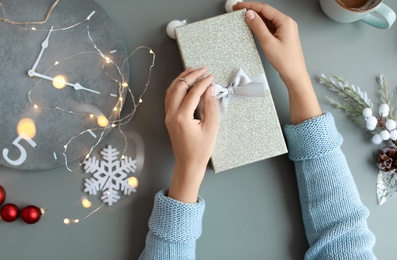 Photo of Woman with Christmas gift box at table, top view