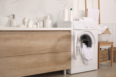 Stylish bathroom interior with modern washing machine