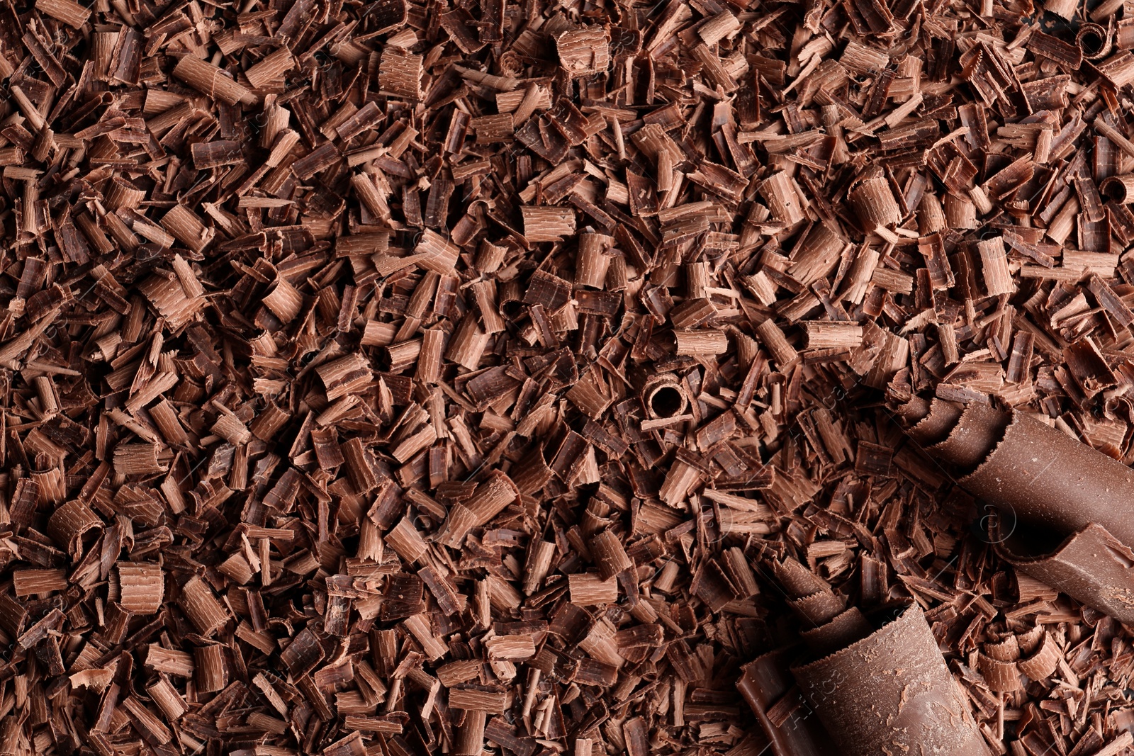 Photo of Pile of tasty chocolate curls as background, top view