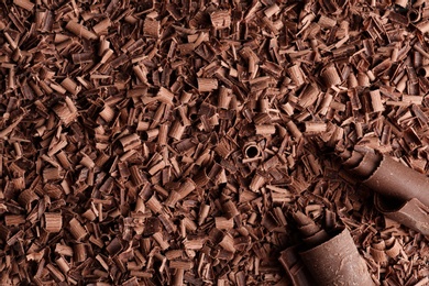 Photo of Pile of tasty chocolate curls as background, top view