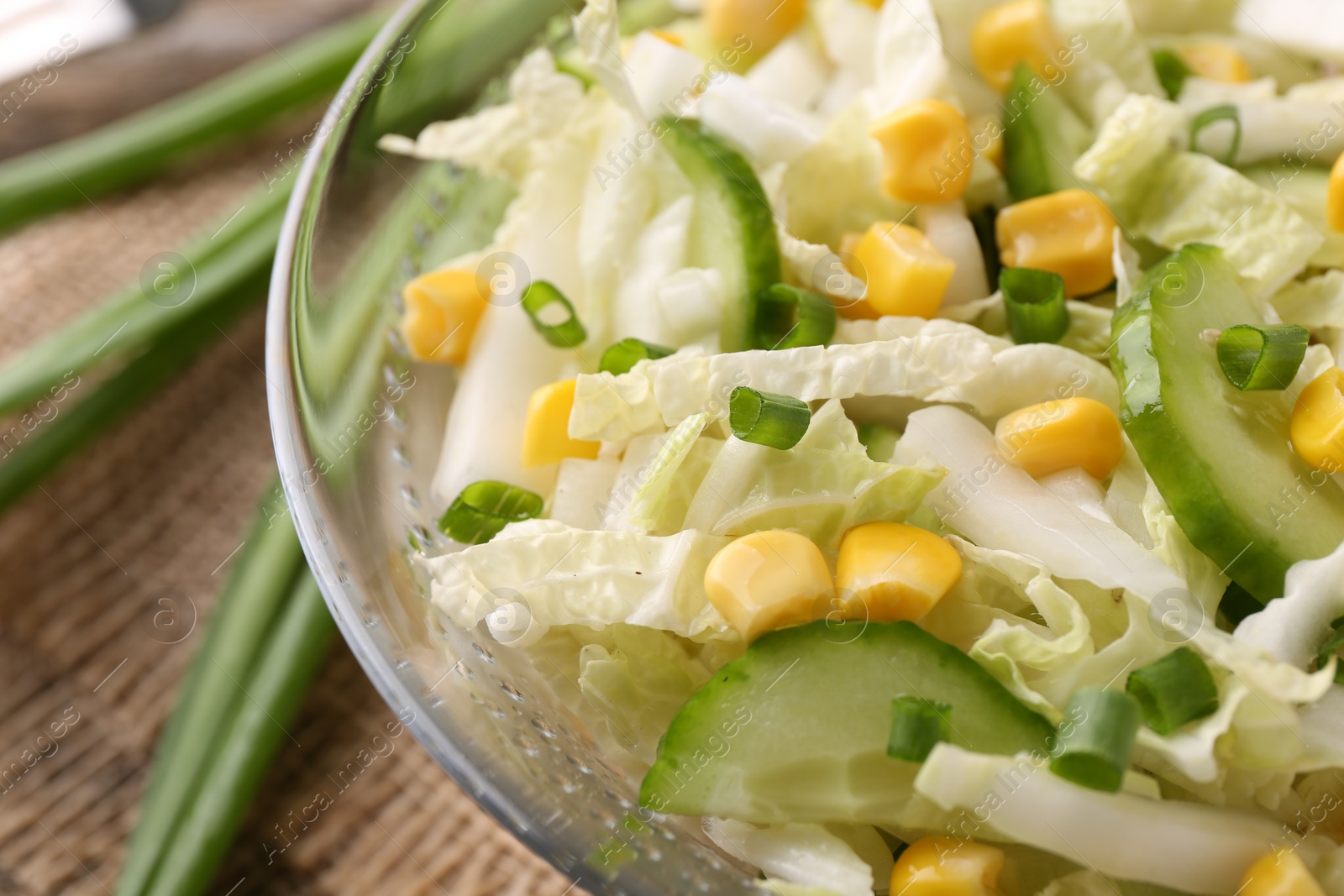 Photo of Tasty salad with Chinese cabbage, corn and cucumber in bowl on table, closeup