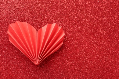 Photo of Decorative paper heart on red shiny background, top view. Space for text