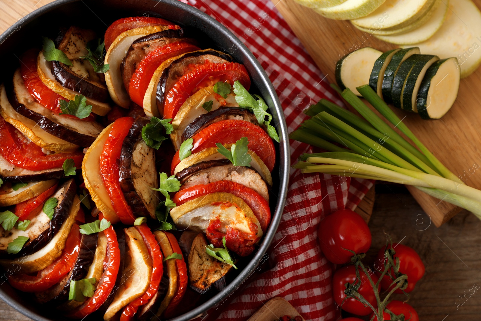 Photo of Delicious ratatouille and ingredients on table, flat lay