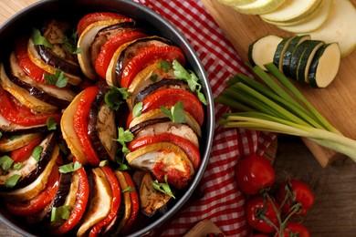 Photo of Delicious ratatouille and ingredients on table, flat lay