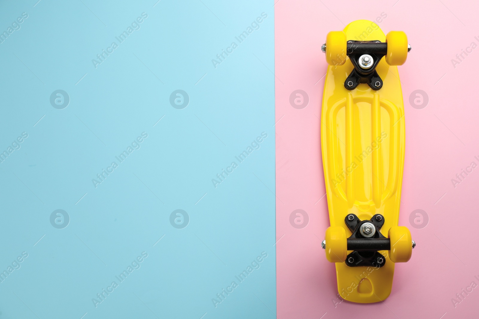 Photo of Yellow skateboard on color background, top view. Space for text