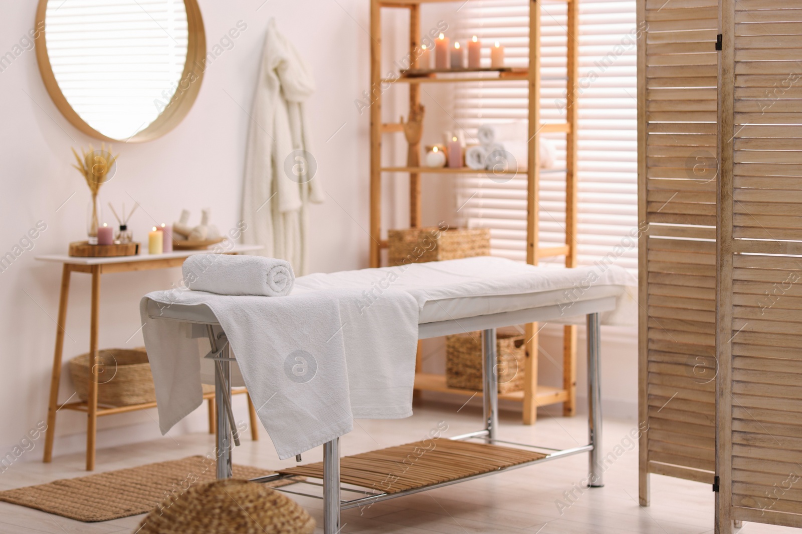 Photo of Comfortable massage table with clean towels in spa center