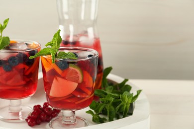Delicious Red Sangria and ingredients on white table, space for text
