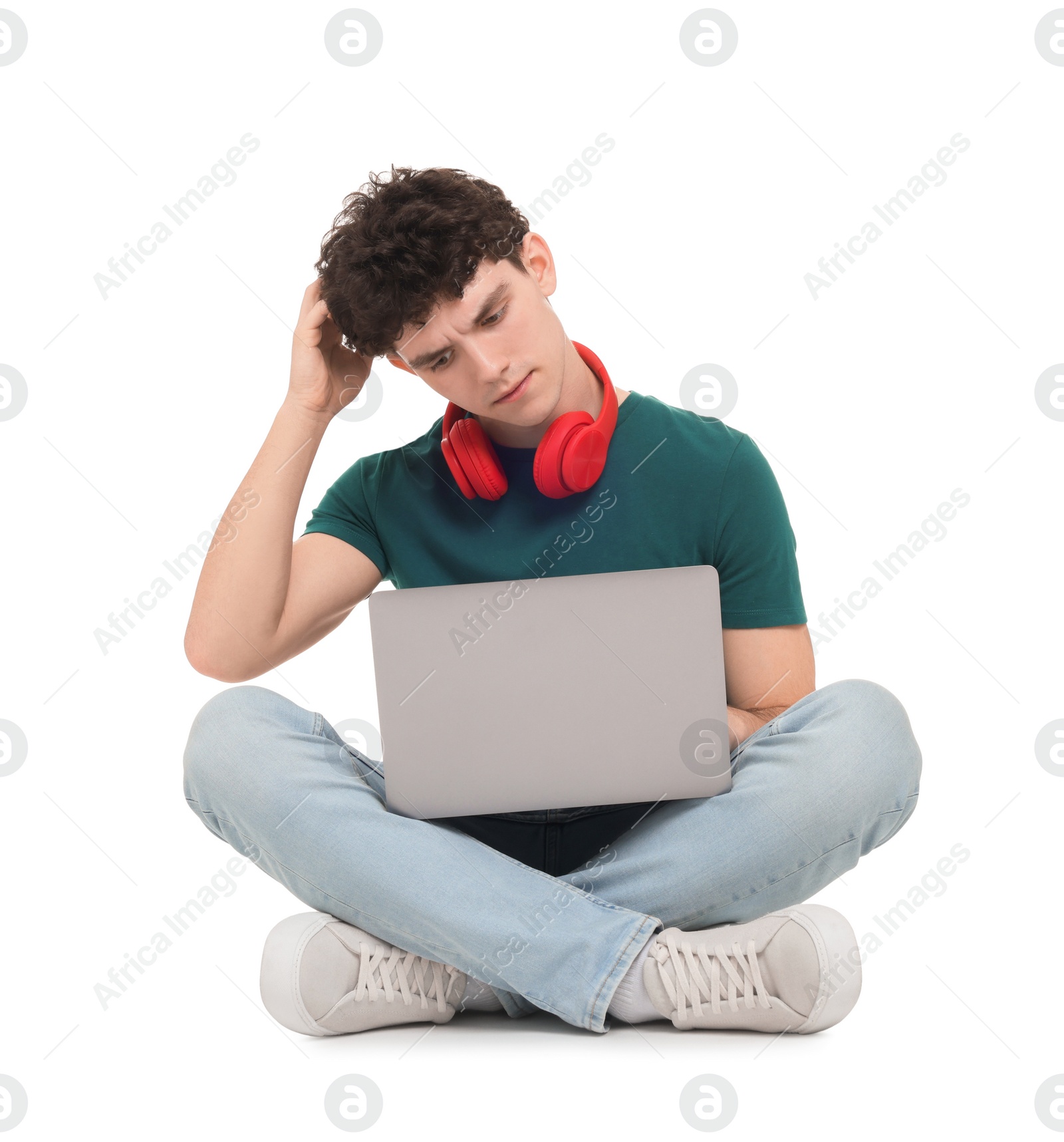 Photo of Portrait of student with laptop and headphones sitting on white background