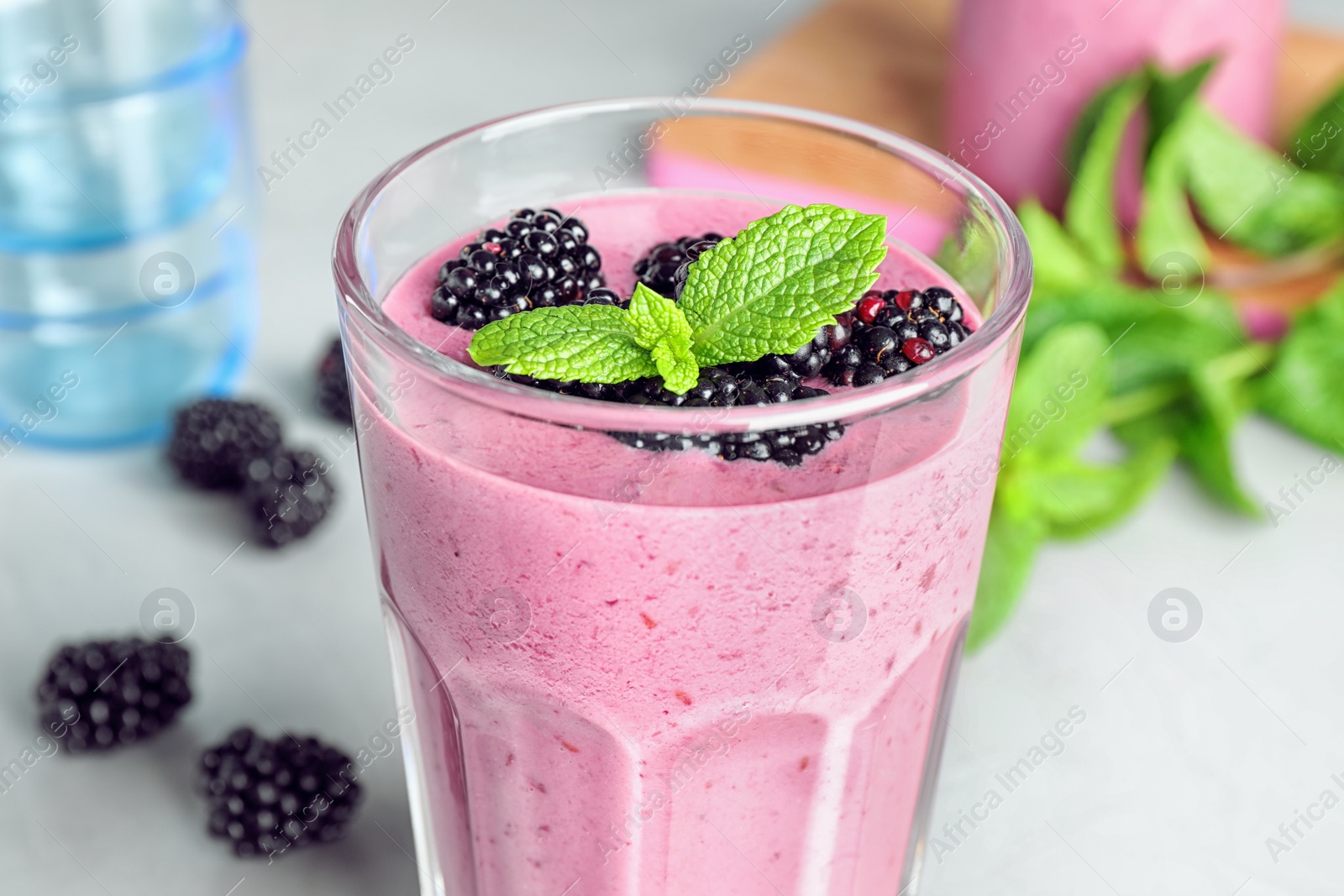 Photo of Glass of blackberry smoothie on table, closeup