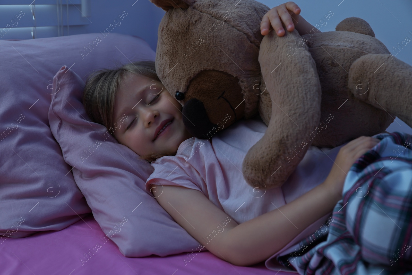 Photo of Little girl snoring while sleeping in bed at home