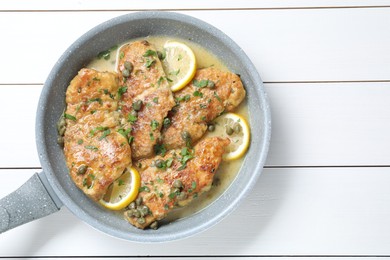 Photo of Delicious chicken piccata on white wooden table, top view