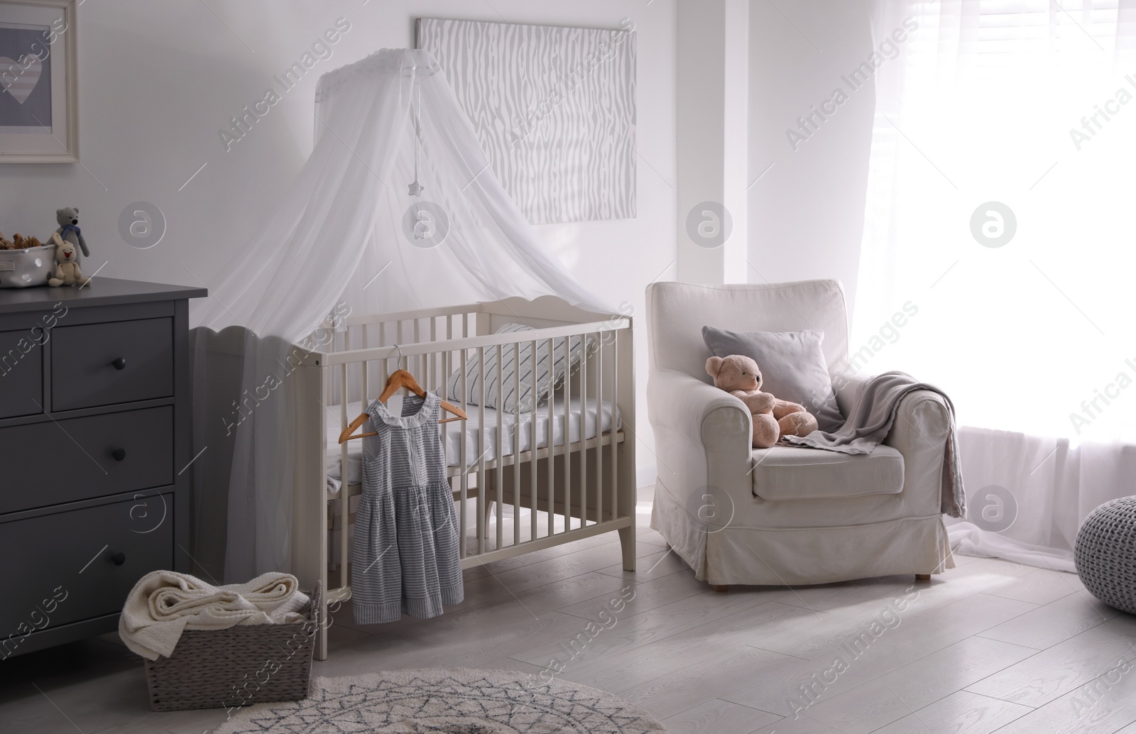 Photo of Baby room interior with comfortable crib and armchair