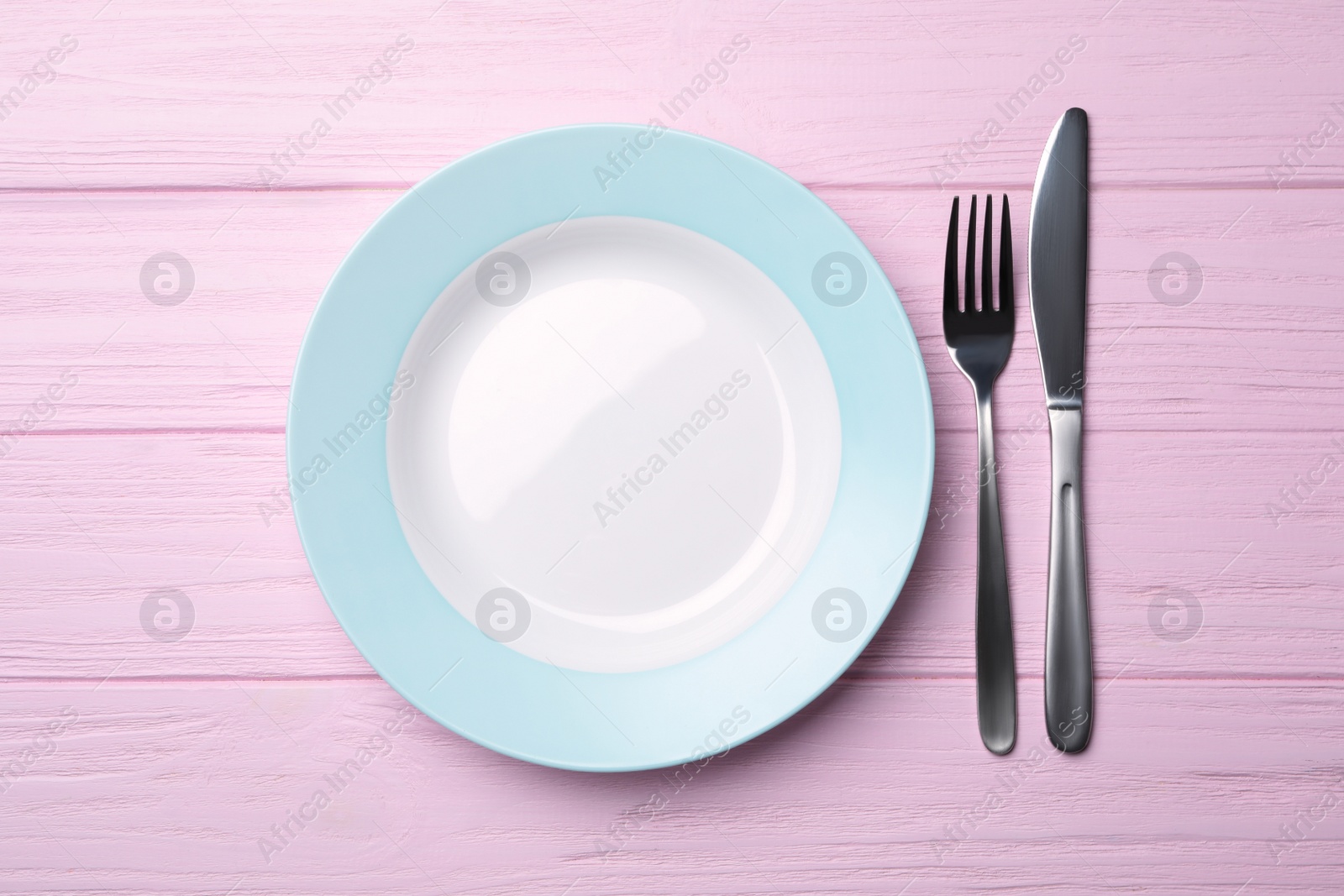 Photo of Stylish ceramic plate and cutlery on wooden background, flat lay