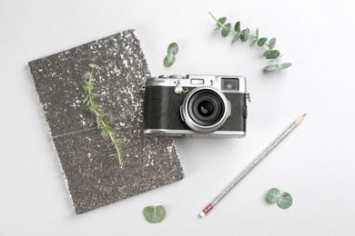 Photo of Flat lay composition with camera for professional photographer and stationery on light background