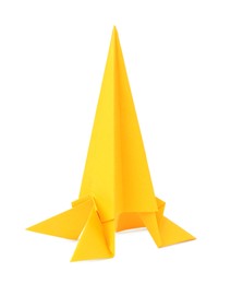 Photo of Origami art. Handmade yellow paper rocket on white background