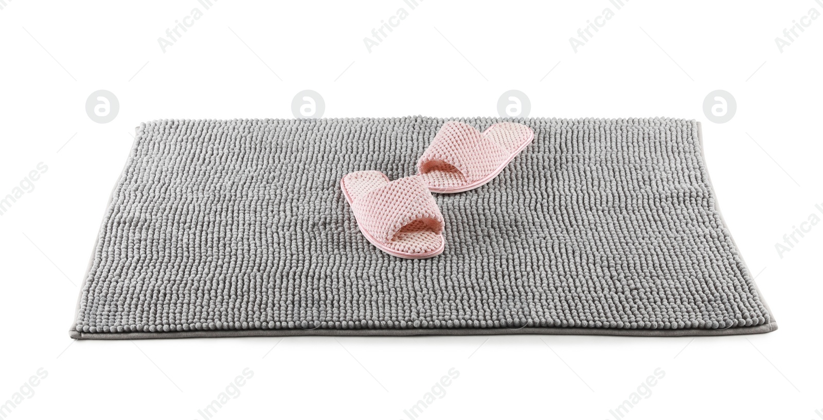 Photo of New grey bath mat with soft slippers isolated on white