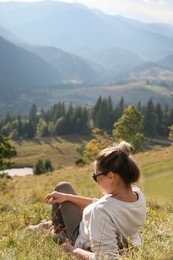 Photo of Woman enjoying beautiful mountain landscape on sunny day