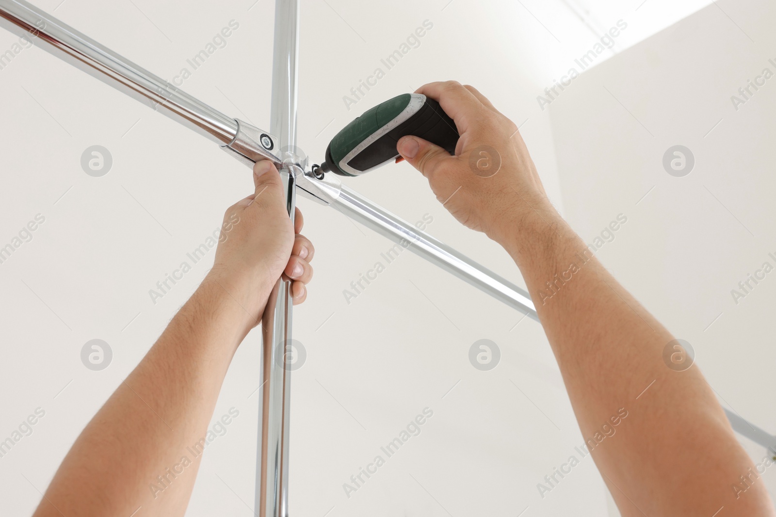 Photo of Worker installing new metal pipes indoors, closeup