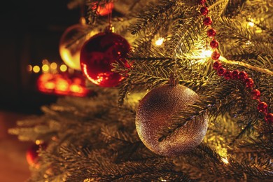 Photo of Closeup of beautiful bauble and festive lights hanging on Christmas tree