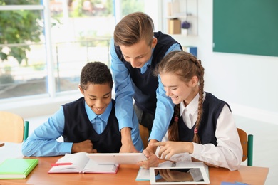 Photo of Teenage students in classroom. Stylish school uniform