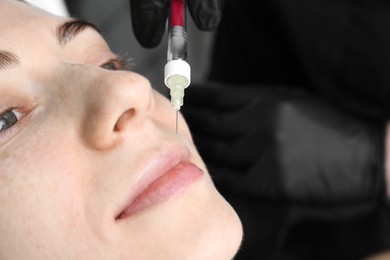 Photo of Cosmetologist giving lips injection to patient, closeup. Cosmetic surgery