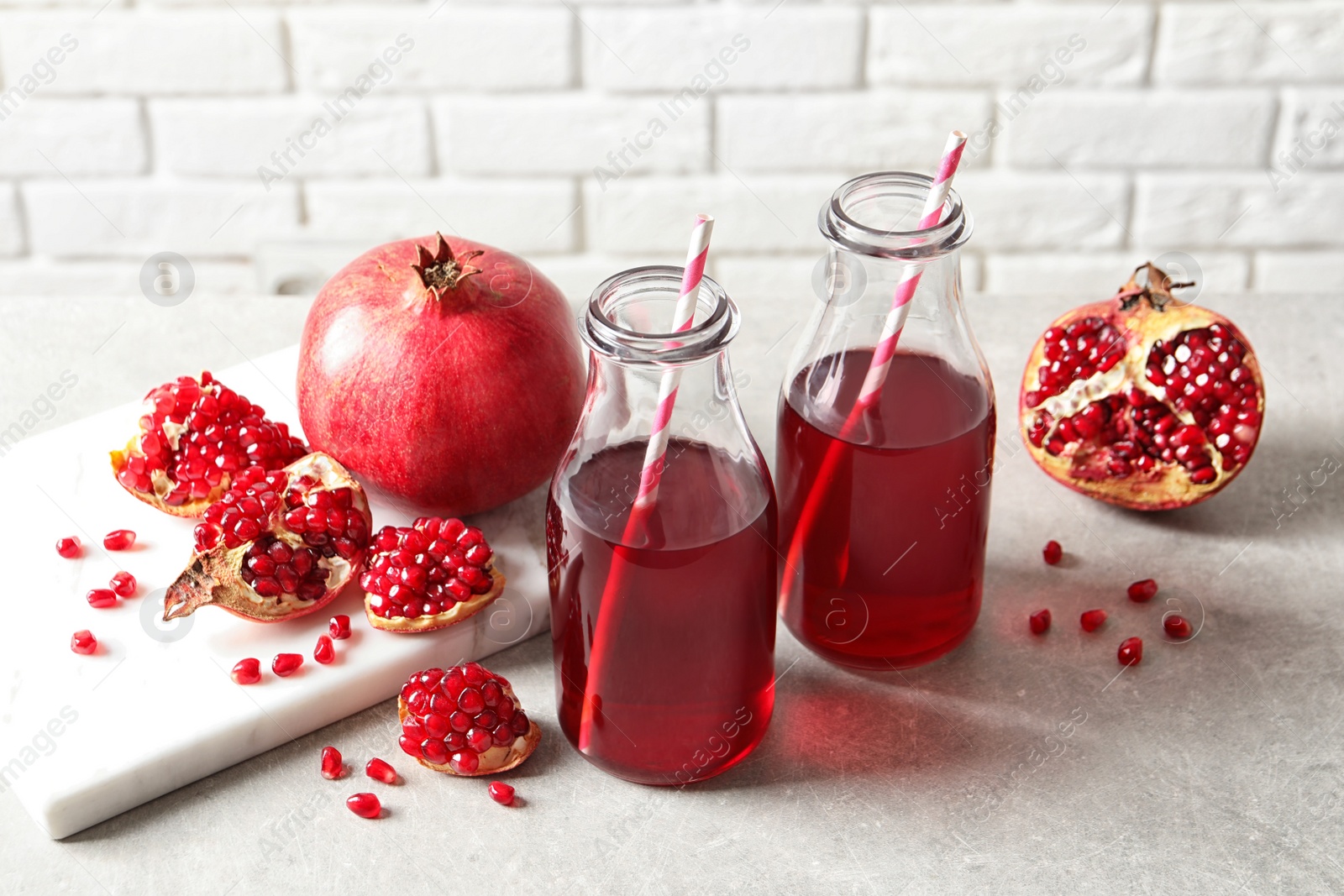 Photo of Composition with bottles of fresh pomegranate juice on table