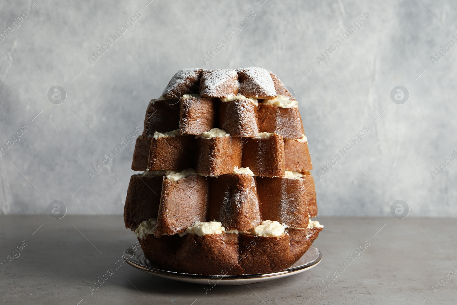 Photo of Delicious Pandoro Christmas tree cake decorated with powdered sugar on grey table