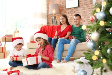 Photo of Happy parents and children celebrating Christmas together at home