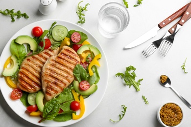 Photo of Tasty grilled chicken fillets with vegetables served on light grey table, flat lay