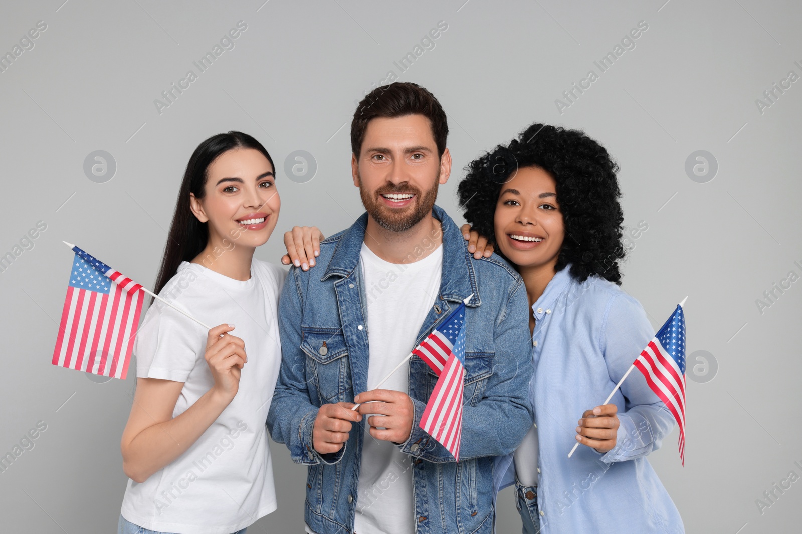 Photo of 4th of July - Independence Day of USA. Happy friends with American flags on grey background