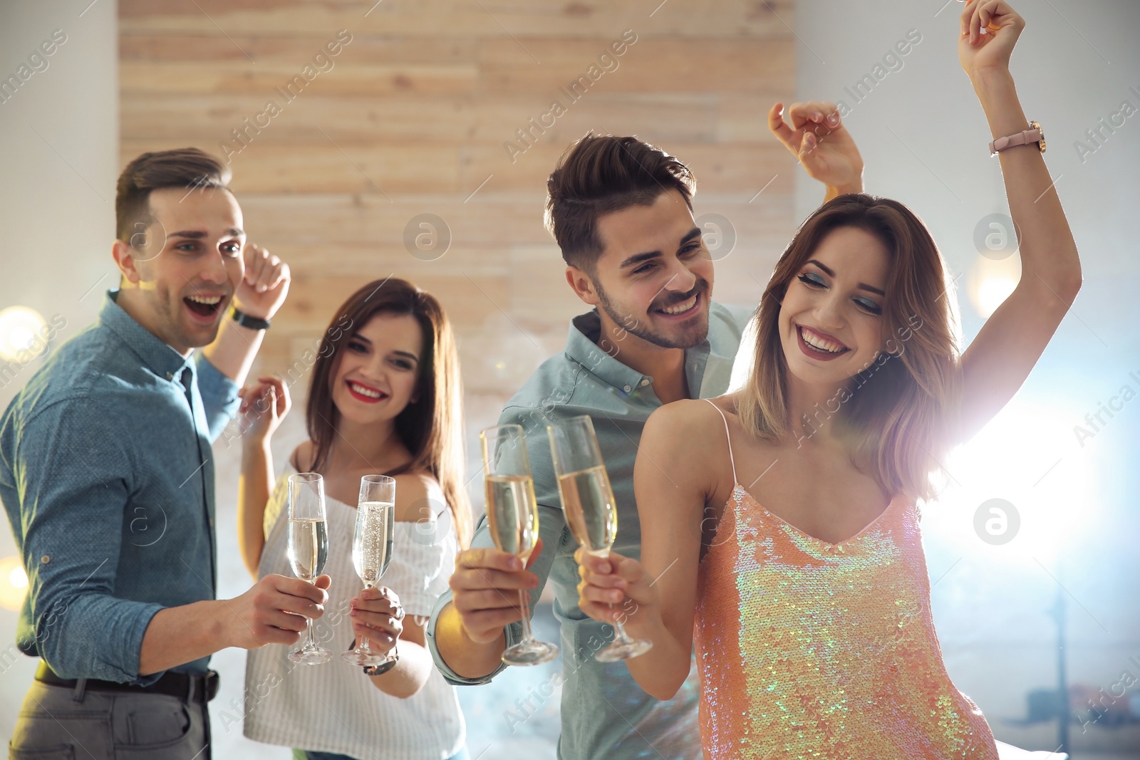 Photo of Friends clinking glasses with champagne at party indoors