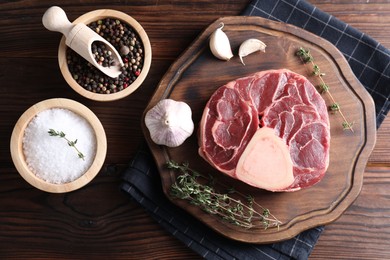 Photo of Flat lay composition of raw beef meat and spices on wooden table