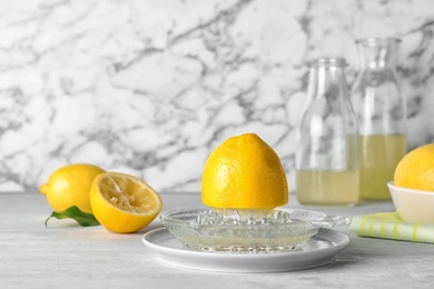 Photo of Composition with glass squeezer and lemon half on table