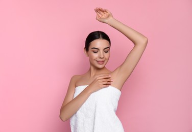 Photo of Young woman showing smooth skin after epilation on pink background