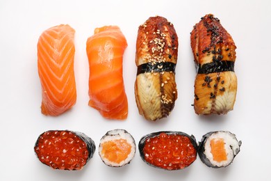 Photo of Delicious sushi rolls on white background, flat lay