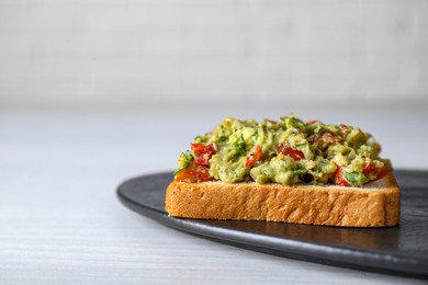 Photo of Delicious sandwich with guacamole on white table, closeup. Space for text