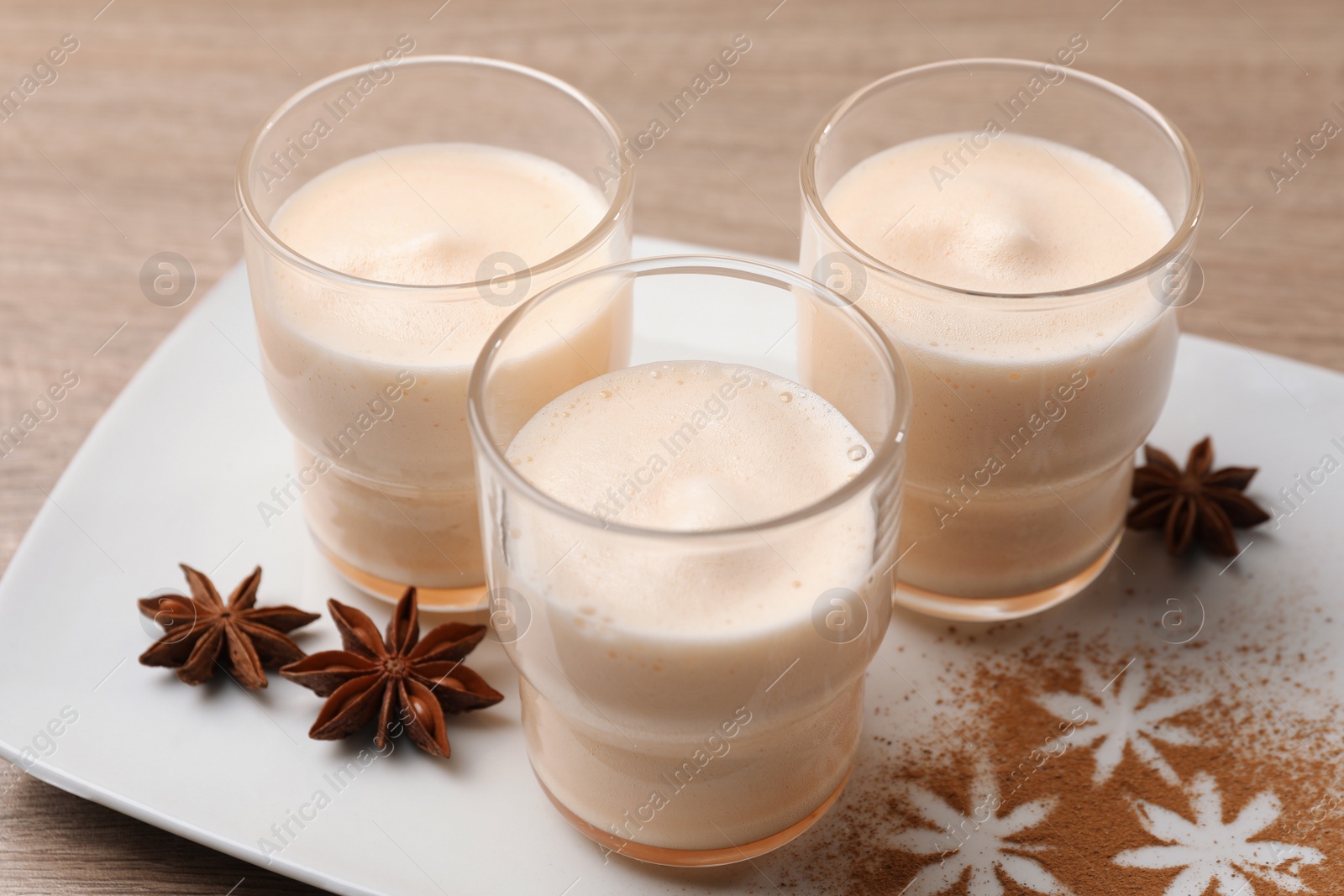 Photo of Delicious eggnog with anise on wooden table