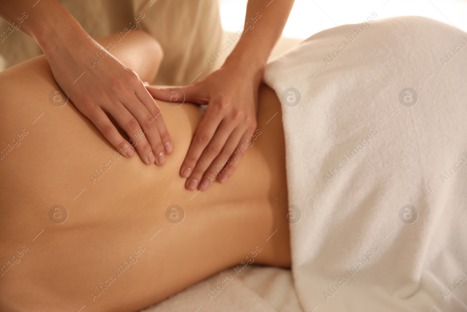 Photo of Young woman receiving back massage in spa salon, closeup
