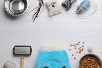 Photo of Flat lay composition with cat clothes, food and accessories on white wooden table. Space for text