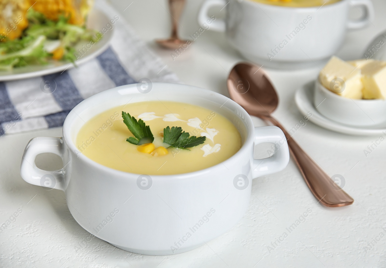 Photo of Delicious corn cream soup served on white table