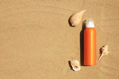 Photo of Sunscreen and seashells on sand, flat lay with space for text. Sun protection care