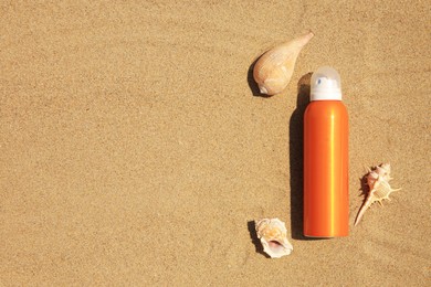 Sunscreen and seashells on sand, flat lay with space for text. Sun protection care