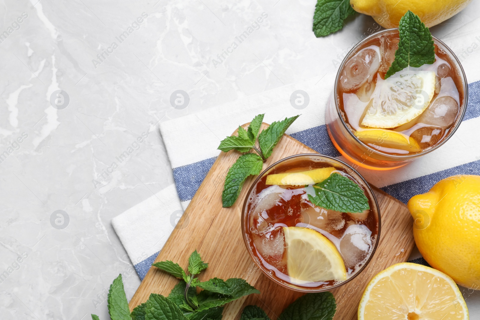 Photo of Delicious iced tea on light grey marble table, flat lay. Space for text