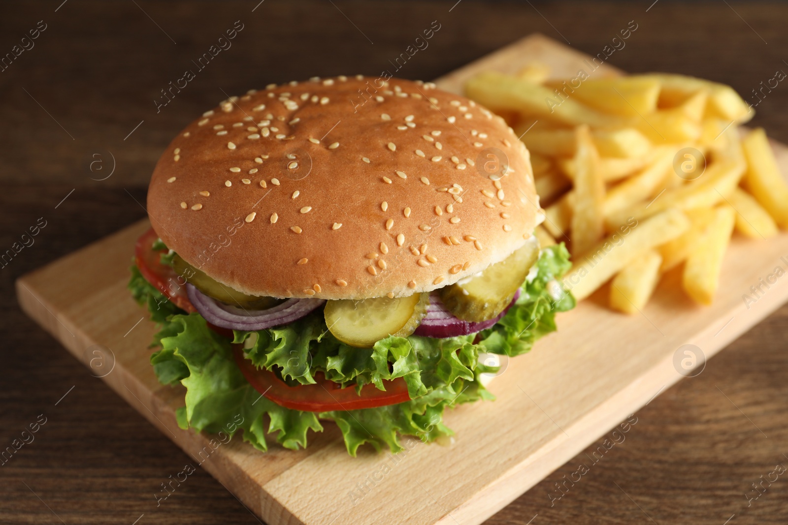 Photo of Delicious burger with beef patty and french fries on wooden table, closeup