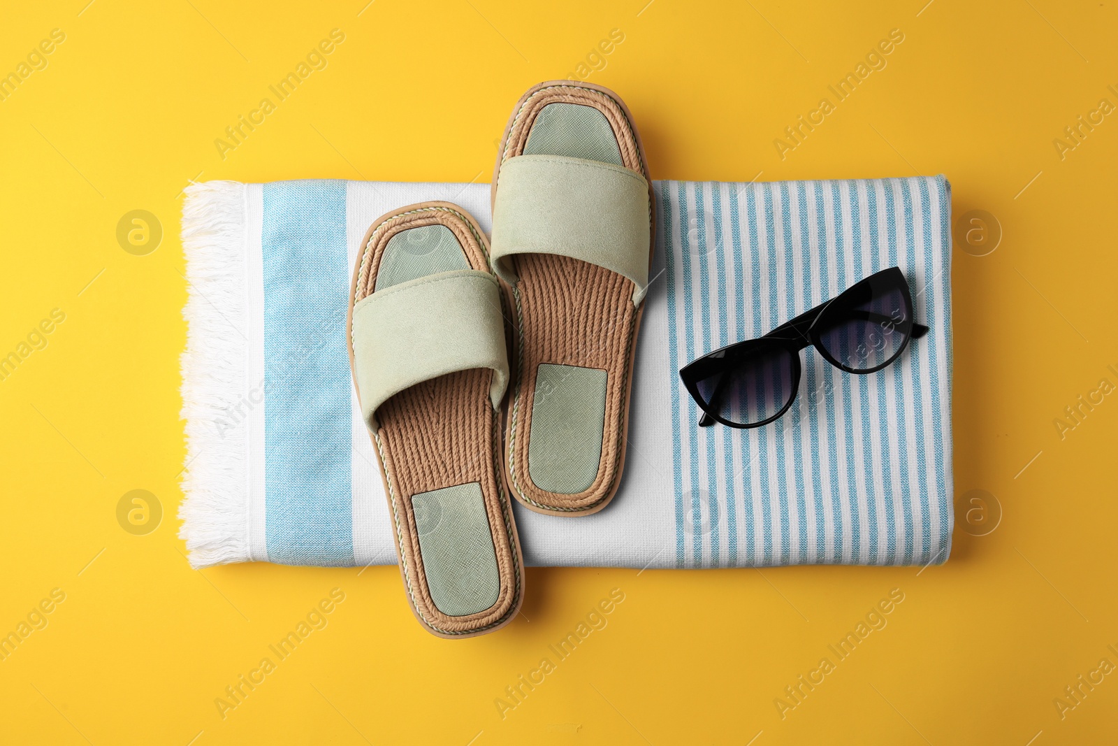 Photo of Flat lay composition with beach accessories on yellow background