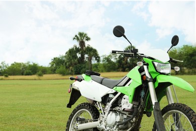 Photo of Stylish green cross motorcycle outdoors, space for text